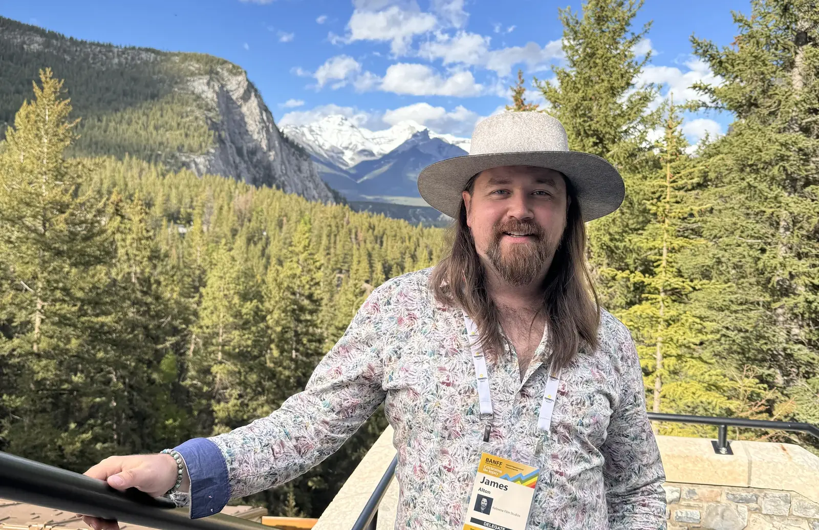James Alton wearing a Banff World Media Festival delegate badge with the Banff mountains behind him
