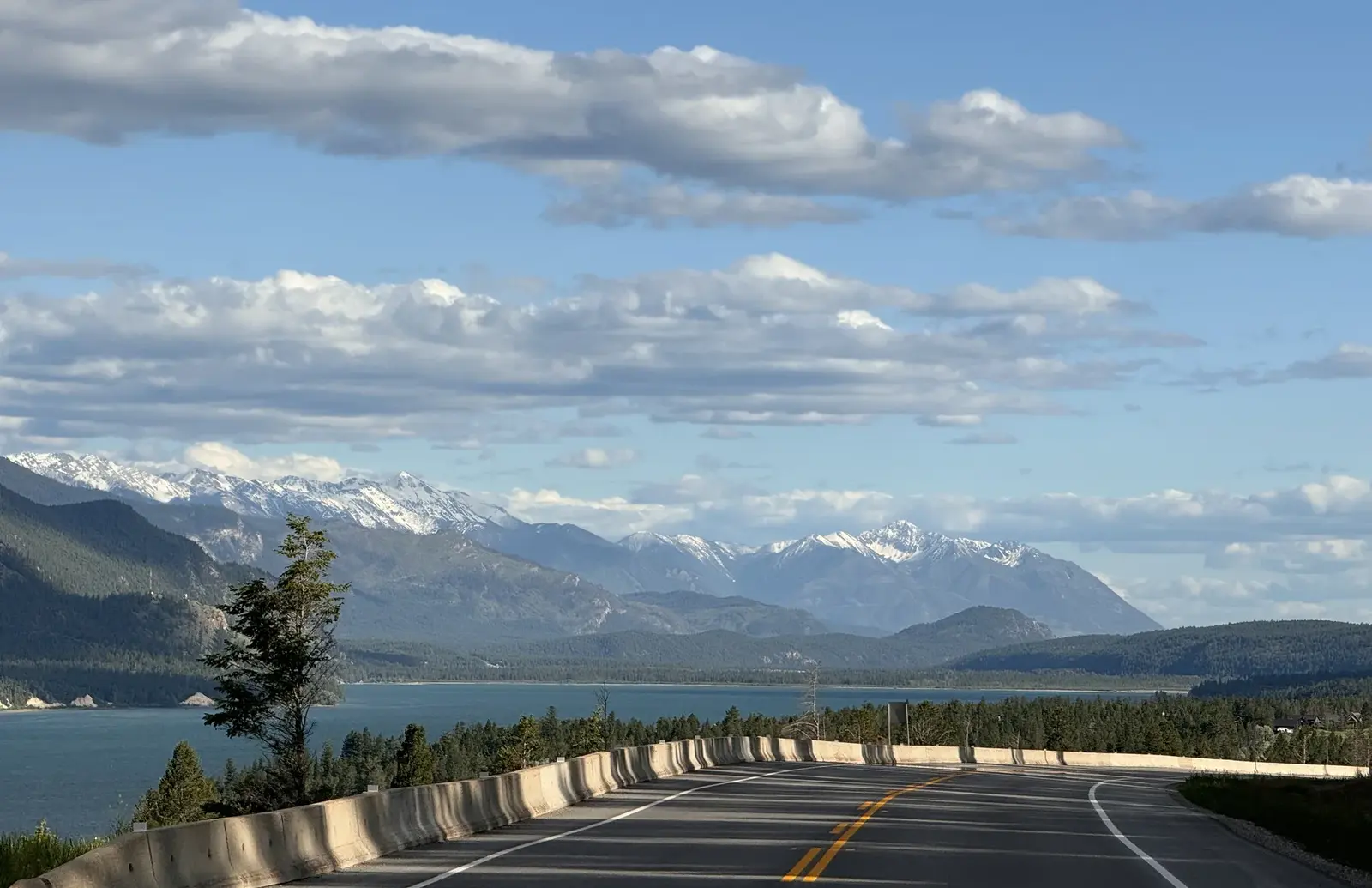 Road through Banff with mountains and water in the distance