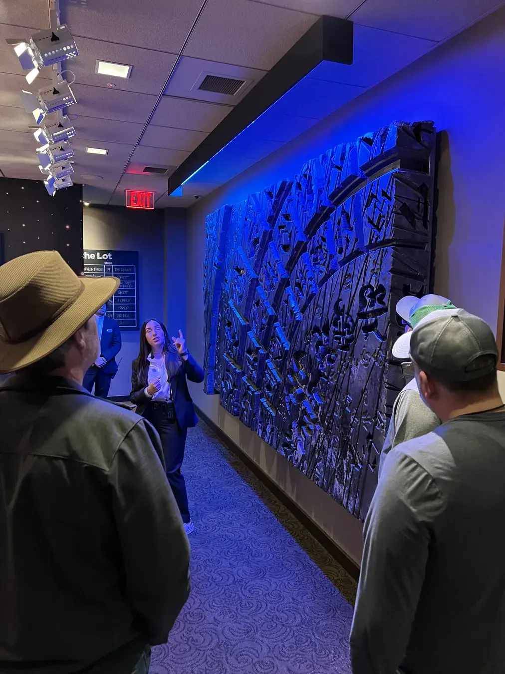 Paramount studio tour guide speaking beside a wall display on the Paramount lot