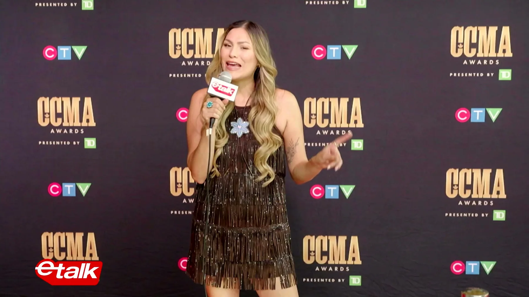Presenter holding an eTalk microphone against the CCMA and CTV red-carpet backdrop