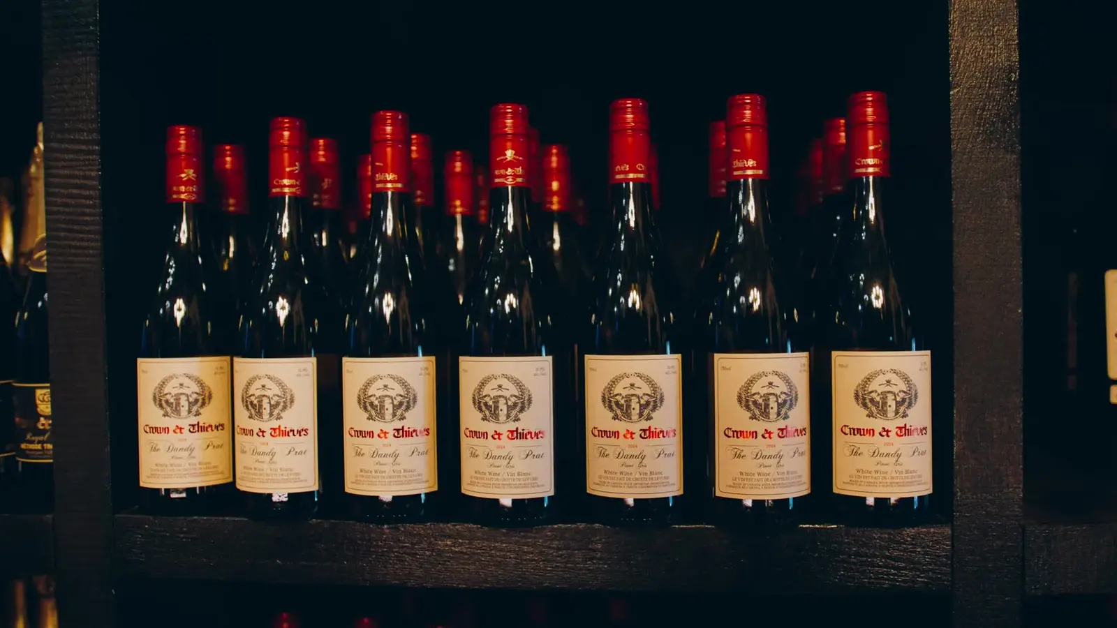 Rows of Crown and Thieves wine bottles from the Jason Parkes Customs commercial