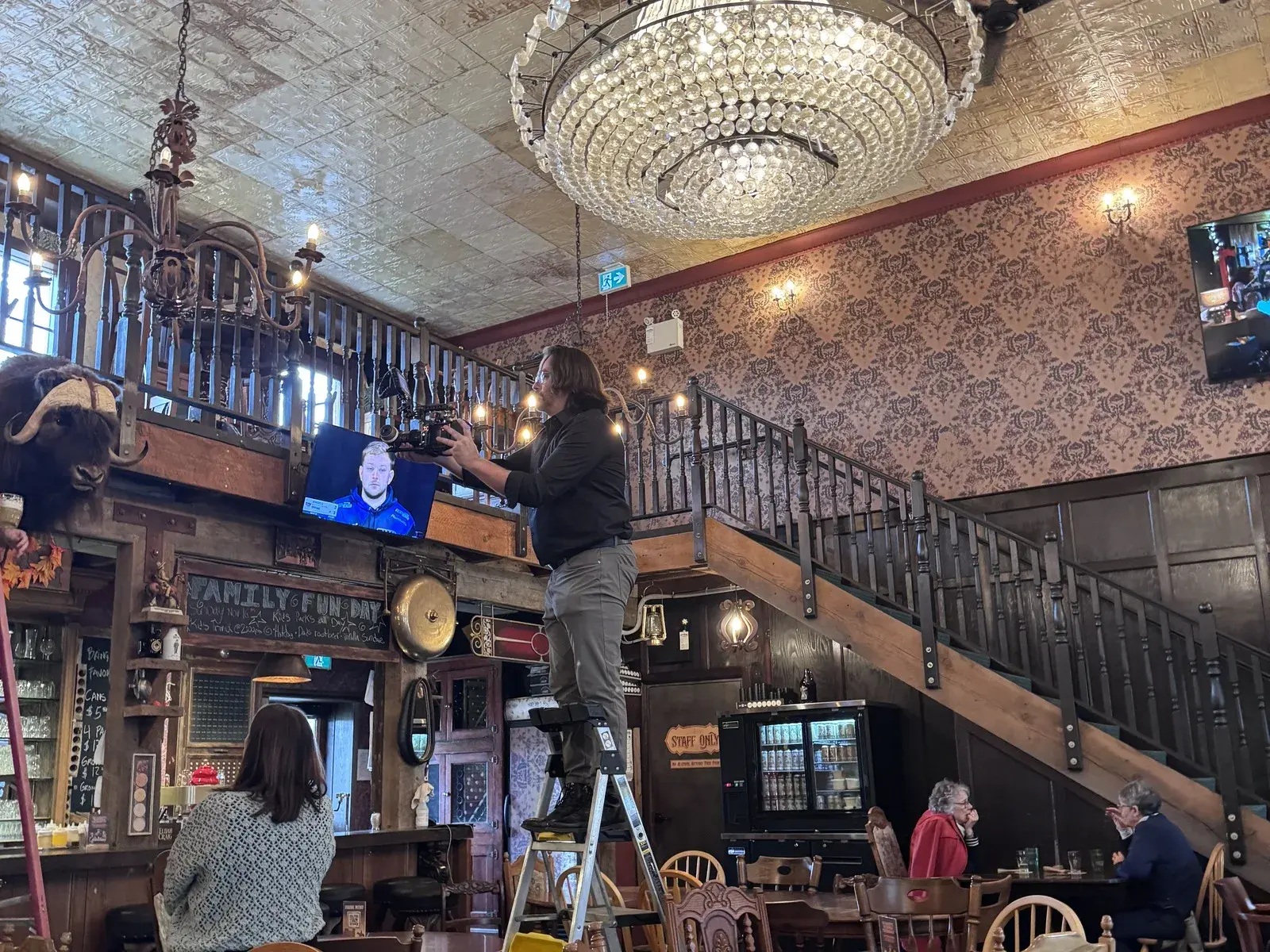 James Alton operating a RED camera on a ladder inside Crown and Thieves during the Jason Parkes Customs commercial shoot