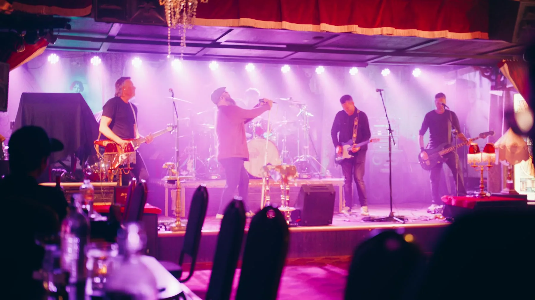 Live music stage in magenta light from the Jason Parkes Customs commercial.