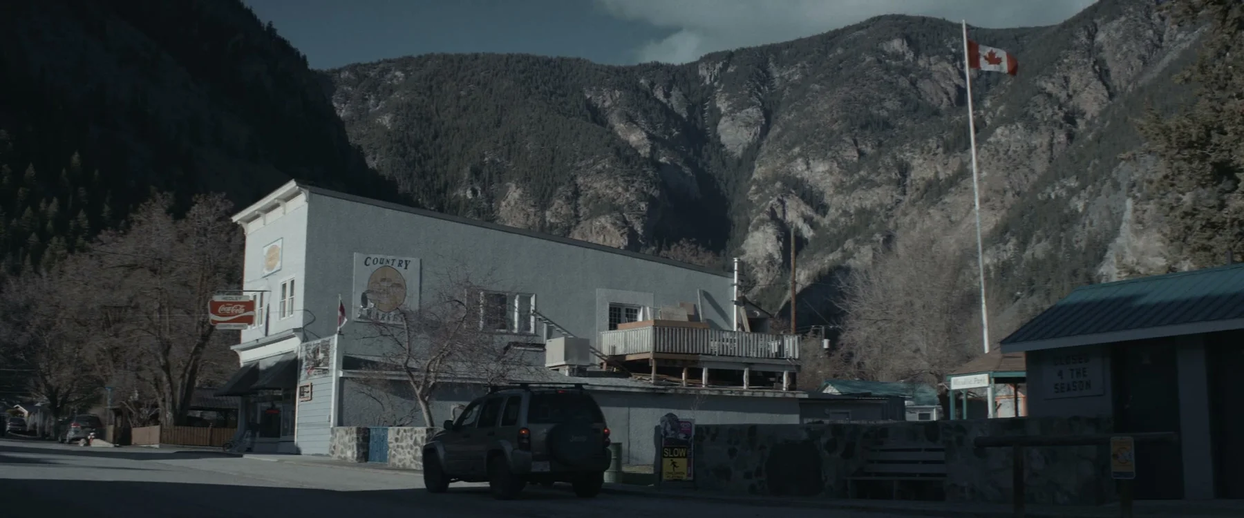 Small-town storefront beneath steep mountains in Mabel