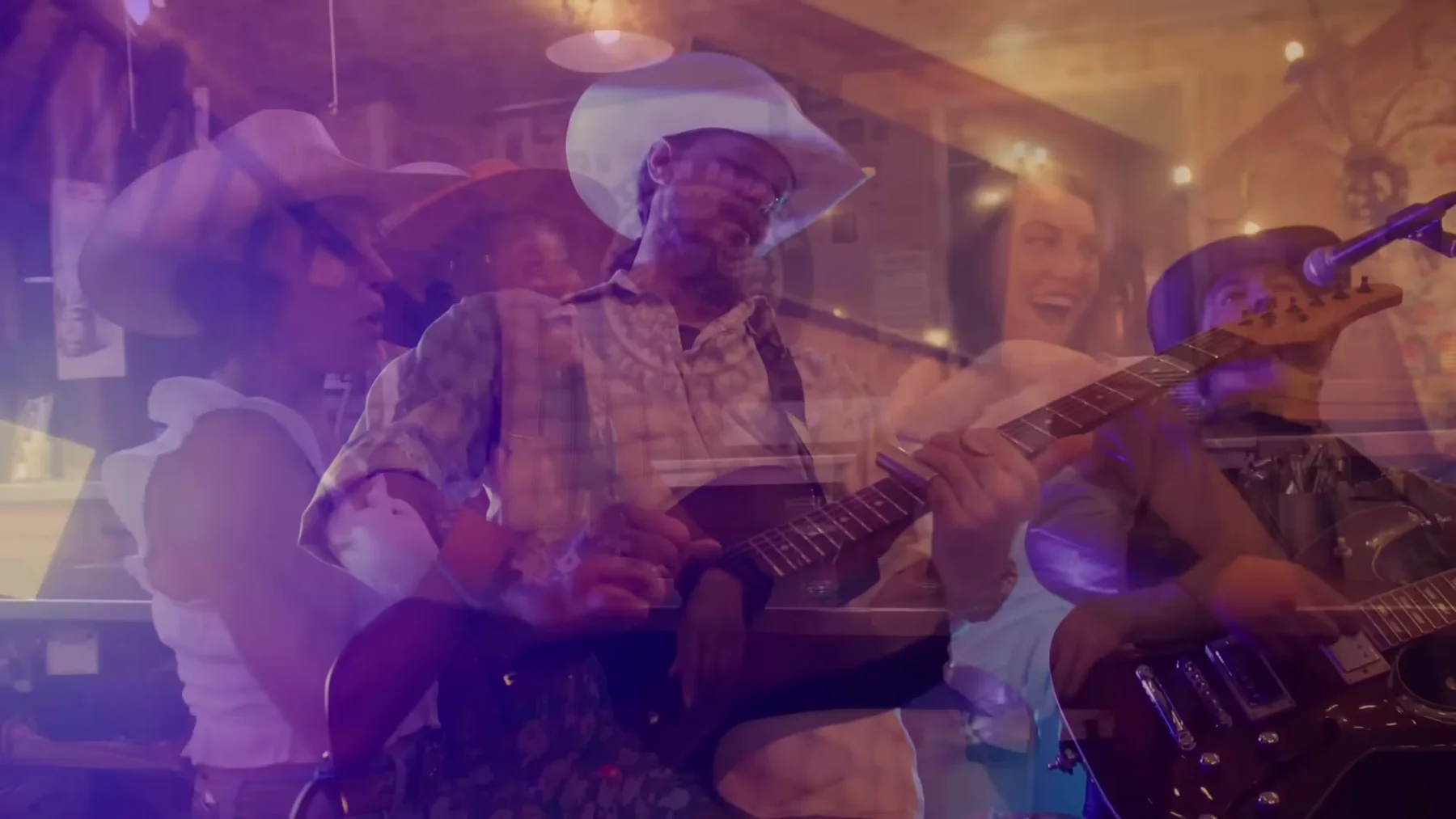 Layered performance frame of Kris Anders and the band in Open Road