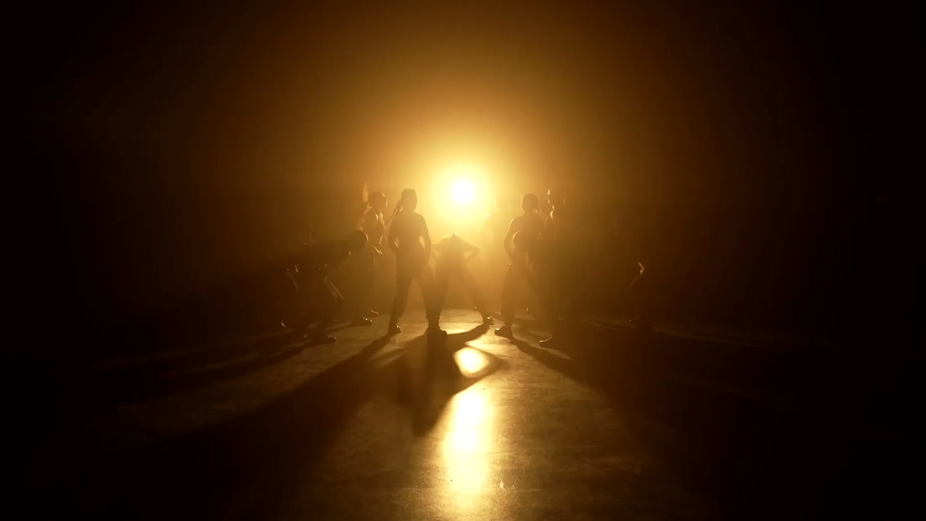 Sockeye dancers silhouetted in amber backlight and haze in the 2023 film