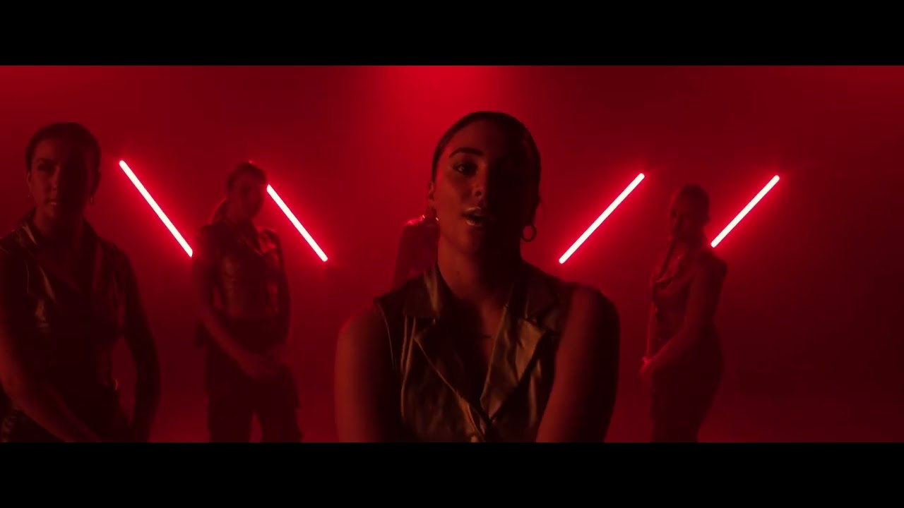 Sockeye dancers performing against red diagonal lights