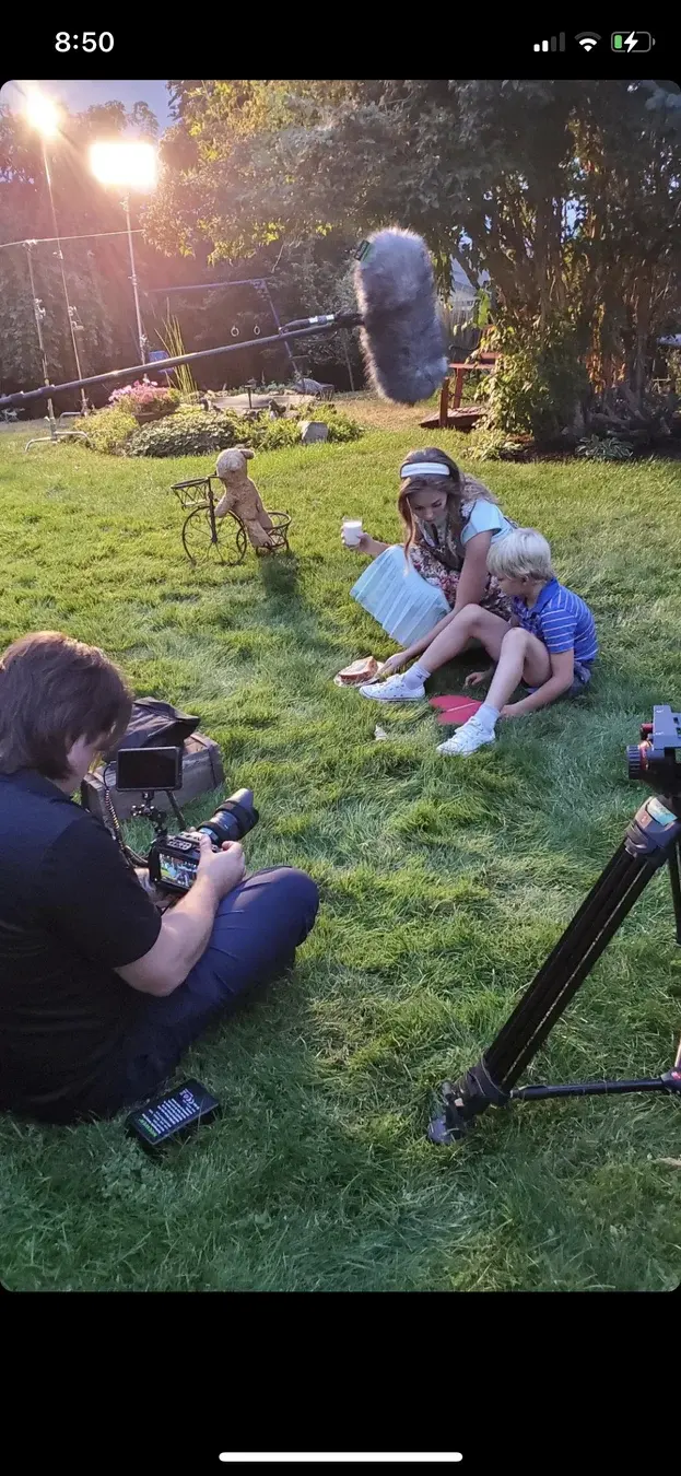 Camera setup near young Dave and young Connie on the grass during Three Hearts