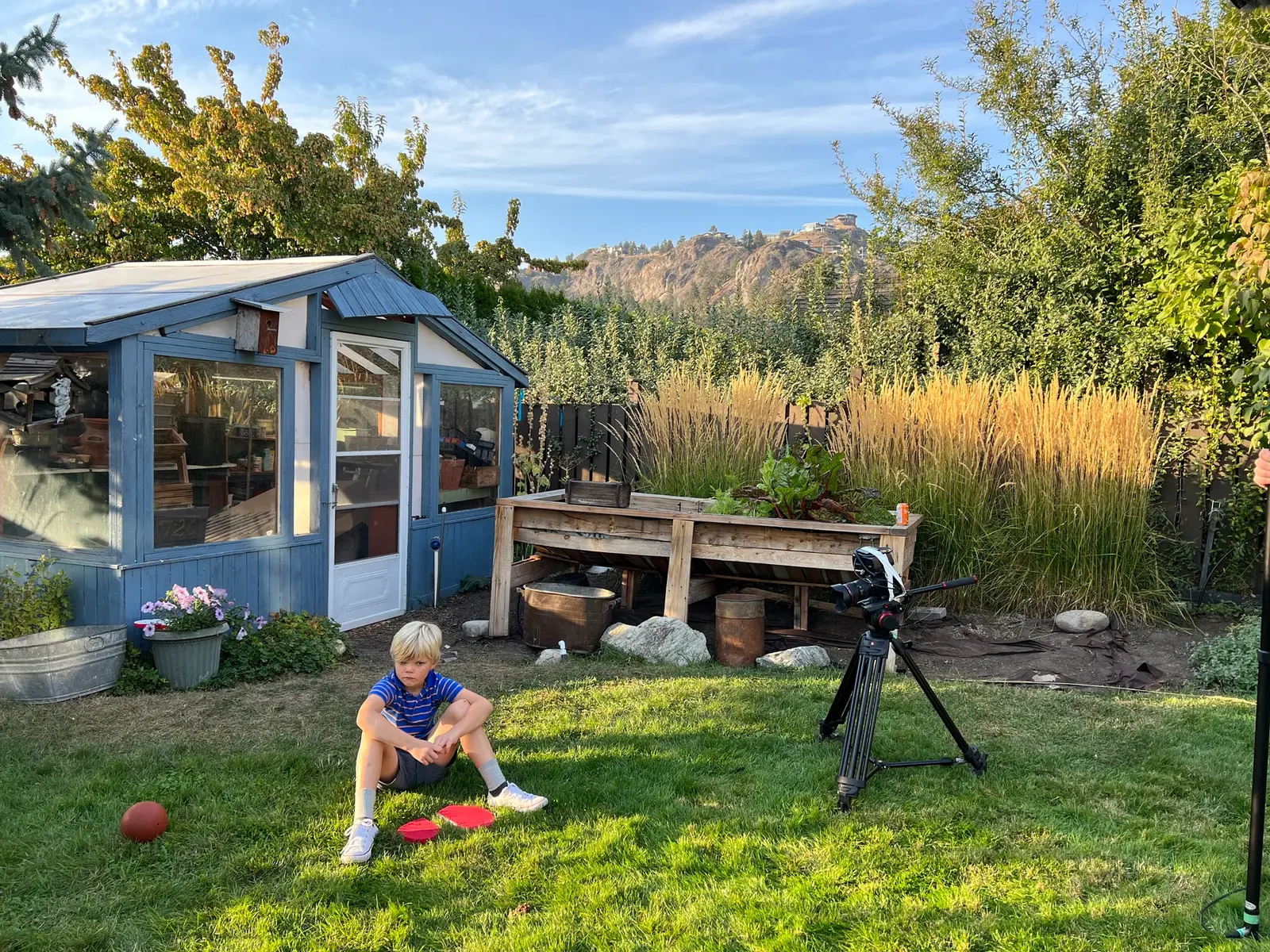 Wide yard BTS frame showing camera setup and young Dave during Three Hearts